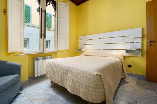 1 dormitorio con 1 cama grande en una habitación amarilla en 19 Lodge en Siena