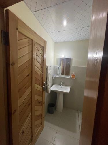 a bathroom with a sink and a wooden door at applegardenhunza in Alīābād