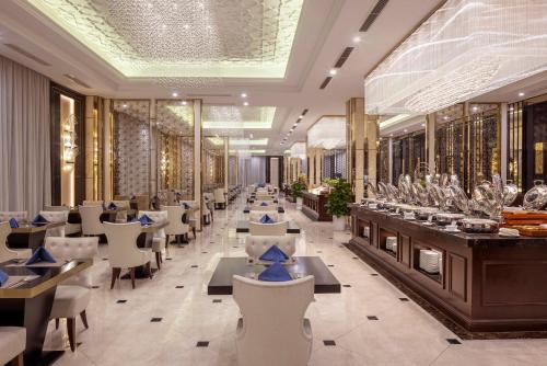Un restaurante con mesas y sillas en una sala. en Meliá Vinpearl Hai Phong Rivera, en Hai Phong