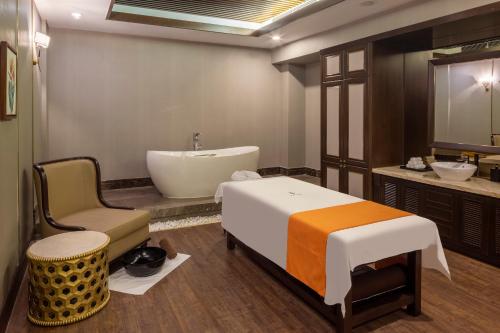 a bathroom with a bed and a sink and a tub at Meliá Vinpearl Hai Phong Rivera in Hai Phong