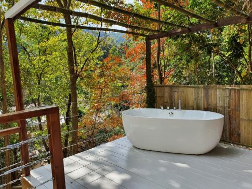 a white bath tub sitting on a deck at เดอะริเวอร์ แม่กำปอง The River Maekampong Chiang Mai in Ban Pok Nai
