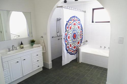 La salle de bains est pourvue d'une douche, d'une baignoire et d'un lavabo. dans l'établissement Ocean View Beachfront, à Bermagui