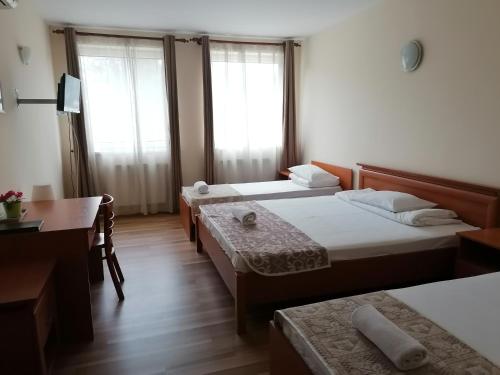 Habitación de hotel con 2 camas y escritorio en Hotel Ferihegy, en Vecsés