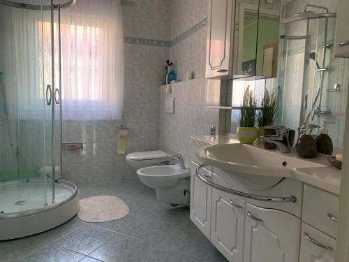 ein Badezimmer mit zwei Waschbecken, einem WC und einer Dusche in der Unterkunft Sweet Home Apartment in Maribor