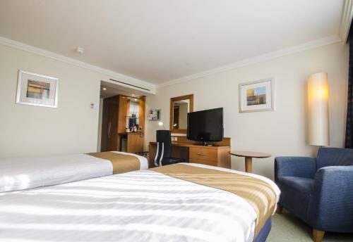 a hotel room with two beds and a tv at Holiday Inn Norwich, Ipswich Road, an IHG Hotel in Norwich