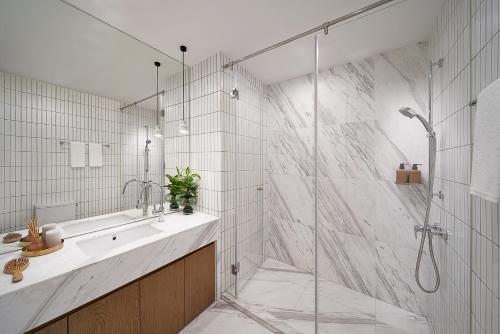 a bathroom with a shower and a sink and a shower stall at basePLUS-BINJIANG Serviced Apartment in Shanghai