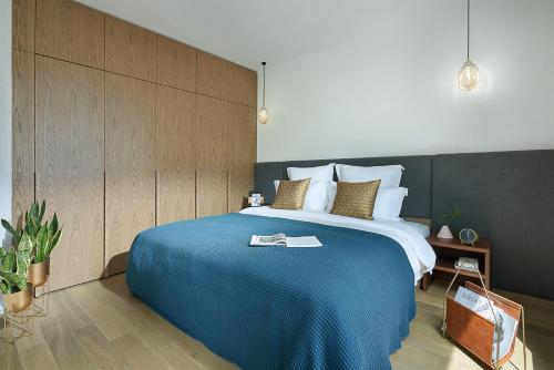 a bedroom with a large bed with a blue blanket at basePLUS-BINJIANG Serviced Apartment in Shanghai