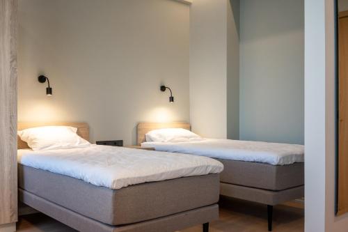 two twin beds in a room with white walls at Espak Hostel in Tallinn