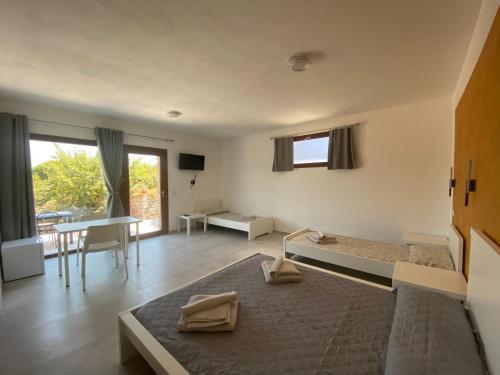 a bedroom with a bed and a table and a desk at Casa Vacanze Alba in Loceri