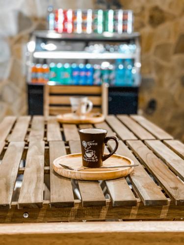 a coffee cup sitting on top of a wooden table at Alaqur View Inn نزل واجهة العقر in Nizwa
