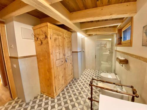 La salle de bains est pourvue d'une armoire en bois et de toilettes. dans l'établissement Luxury Chalet Liosa - Ski in Ski out - Amazing view, à Corvara in Badia