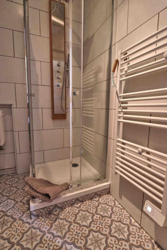une douche avec une porte vitrée dans une salle de bain dans l'établissement jolie cottage idéalement située, à Honfleur