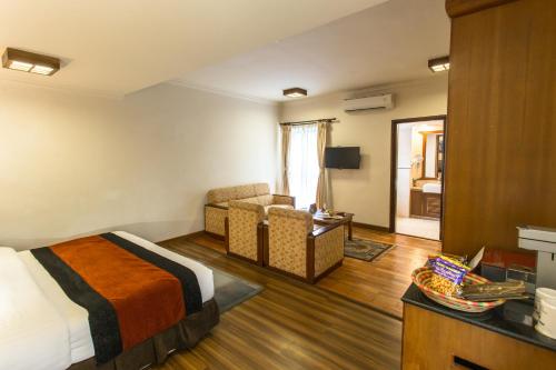 a hotel room with a bed and a couch at Atithi Resort & Spa in Pokhara