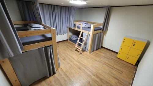 a small room with two bunk beds and a ladder at Able Guesthouse Hongdae 2 in Seoul