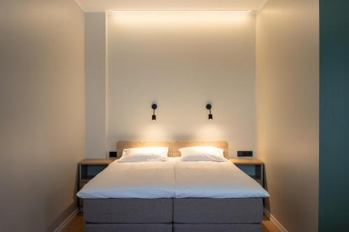 a bedroom with a bed with white sheets and lights at Espak Hostel in Tallinn