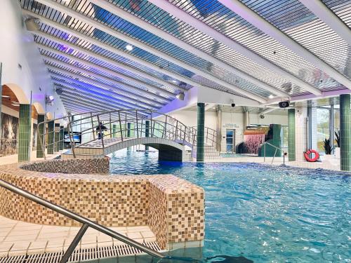 a large swimming pool with a bridge in a building at Ikaalinen SPA & Resort in Ikaalinen