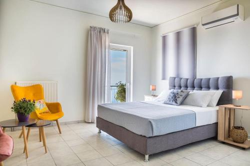 - une chambre avec un grand lit et une chaise jaune dans l'établissement Cactus Apartment, à Céphalonie