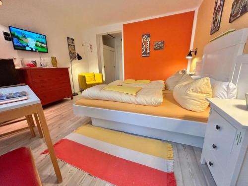 a bedroom with a large bed with an orange wall at Haus am Kurpark in Schömberg