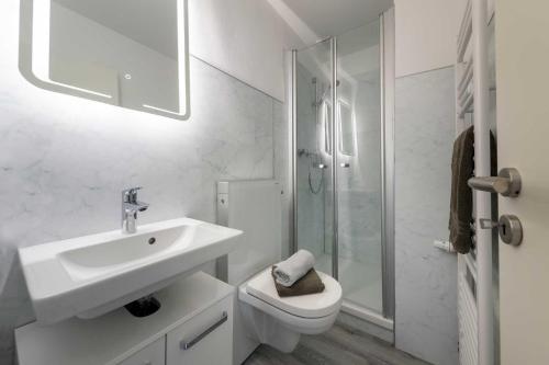 ein weißes Bad mit einem Waschbecken und einem WC in der Unterkunft App. 4 "Midlum" in Böhl
