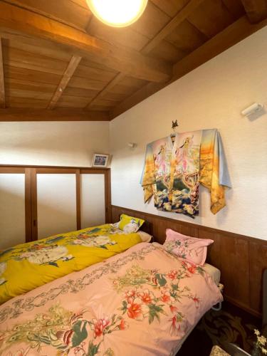 a bedroom with two beds and a painting on the wall at Kyoto Wakouan Retro Stay in Kinugasa