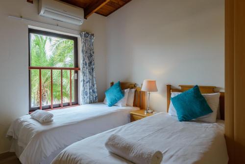 2 camas en una habitación con ventana en San Lameer Villa 3120 - 3 Bedroom Classic - 6 pax - San Lameer Rental Agency, en Southbroom