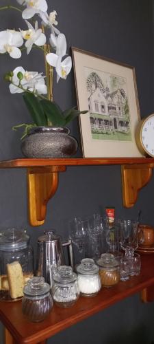 un estante con gafas y un reloj y una foto en Bowden B&B, en Olifantshoek