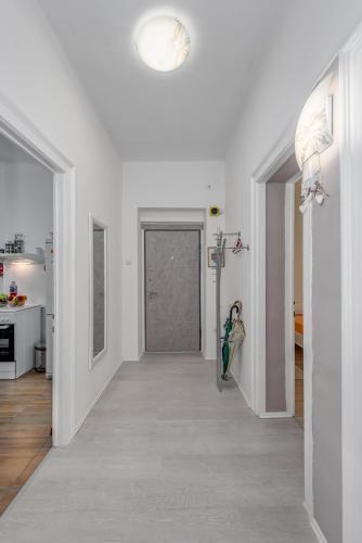 a hallway with a door leading to a room with white walls at Apartment Pape in Split