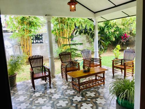 een groep stoelen en een tafel op een patio bij Charitha Rest in Ampara