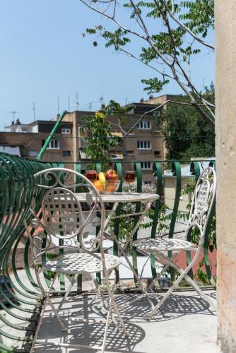 a table and chairs sitting on a balcony with a table and fruit at Apartment Pape in Split