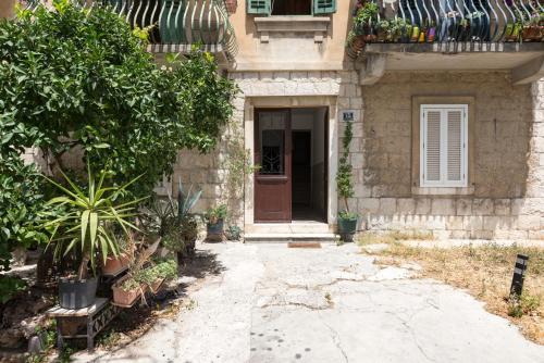 a house with a door and plants in front of it at Apartment Pape in Split