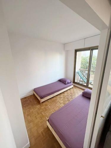 deux lits dans une chambre avec une fenêtre dans l'établissement Entiry apartment, Private rooms in Paris, à Paris