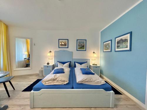 a blue bedroom with a bed and a blue wall at Haus am Kurpark in Schömberg