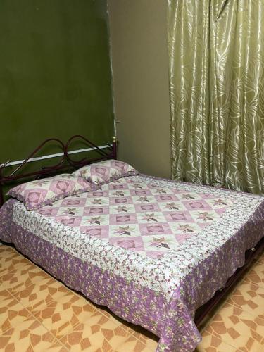 1 dormitorio con 1 cama con edredón en Idaman Sinar Homestay en Nibung Tebal