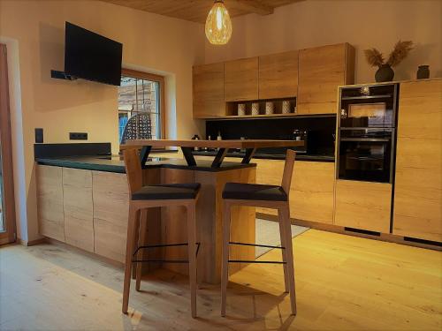 uma cozinha com uma mesa de madeira e cadeiras em Chalet Tuxer em Achenkirch