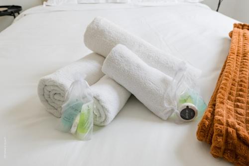 a pile of towels sitting on top of a bed at Les 2 Lys in Brétigny-sur-Orge