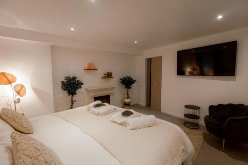 Cette chambre comprend un lit blanc et une télévision murale. dans l'établissement Suite romantique avec Jacuzzi - Hypercentre, Comédie, à Montpellier