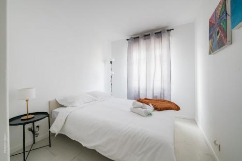 ein weißes Schlafzimmer mit einem Bett und einem Fenster in der Unterkunft Les 2 Lys in Brétigny-sur-Orge