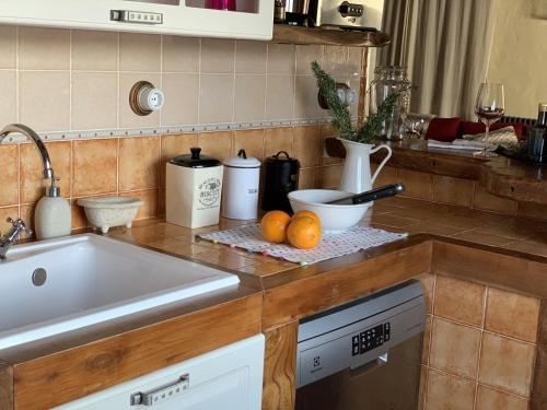 a kitchen with a sink and some oranges on a counter at Casas Rurales Hoces del Duratón in Carrascal del Río