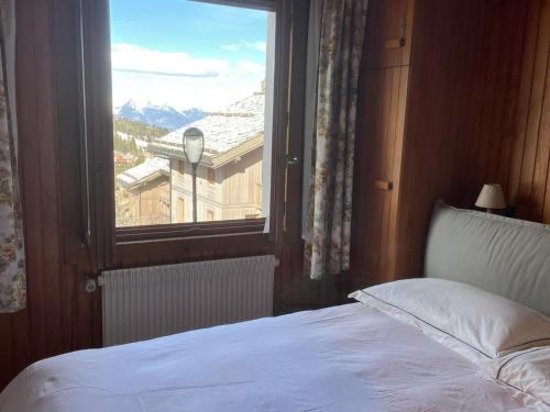 a bedroom with a bed and a window with a view at Lovely Apt Chalet Courchevel 1650 in Courchevel