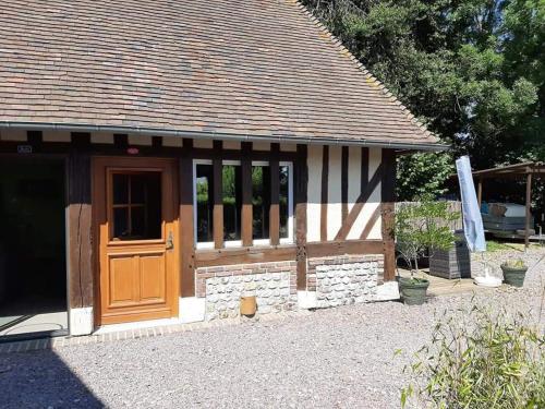 a cottage with a wooden door and a stone wall at lamaisonmelidine in Saint-Mards-de-Blacarville