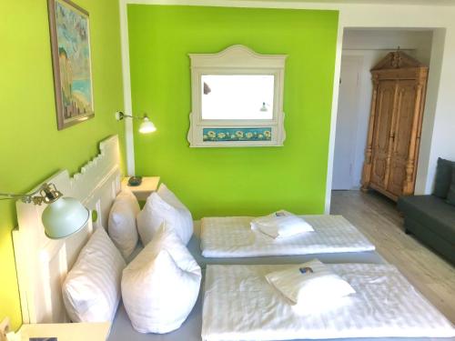 a green room with two beds and a window at Haus am Kurpark in Schömberg