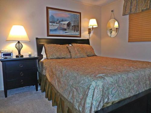 a bedroom with a bed and a night stand with a lamp at ML332 1BR1BA Slope View WiFi Parking Village in Snowshoe