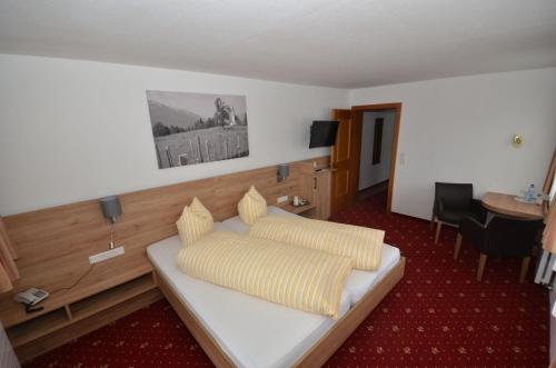 ein Hotelzimmer mit einer Couch mit gelben Kissen in der Unterkunft Pension Spiegl in Seefeld in Tirol