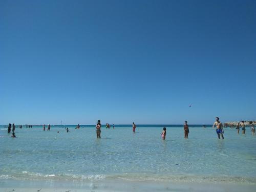 a group of people standing in the water at the beach at A casa mia in Felline