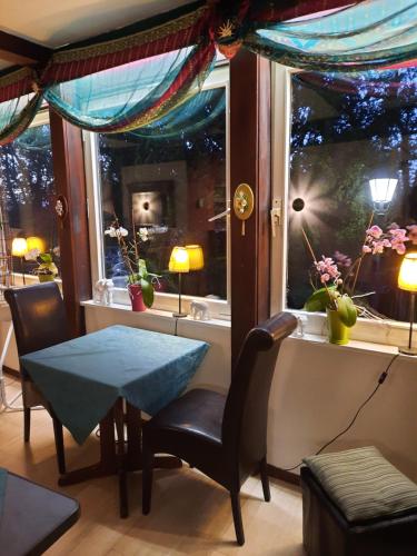 ein Esszimmer mit einem Tisch und einem Fenster in der Unterkunft HOTEL YOGA JASMIN ehemals Hotel Eberhardt-Burghardt in Badenweiler