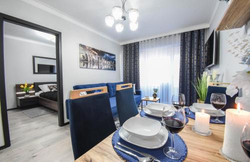 a dining room and living room with a table and chairs at Sun Towers - Apartamenty Bryza - Apartamenty z parkingiem in Świnoujście