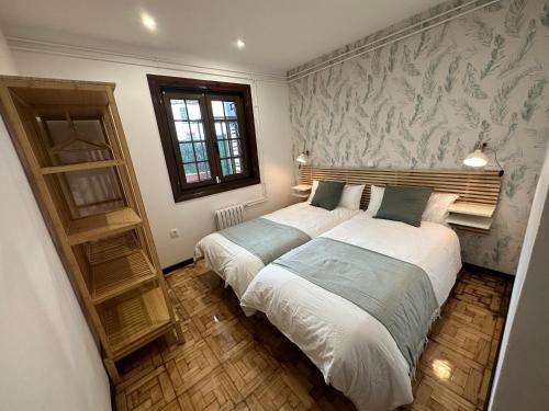 a bedroom with two beds and a wall mural at Apartamento Plaza del Rey in Santillana del Mar