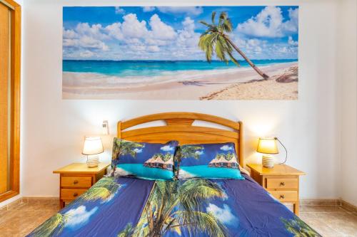a bedroom with a bed and a painting of a beach at Apartamento en el Cabo roig in Orihuela