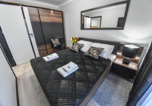 a bedroom with a bed with two towels on it at Sun Towers - Apartamenty Bryza - Apartamenty z parkingiem in Świnoujście