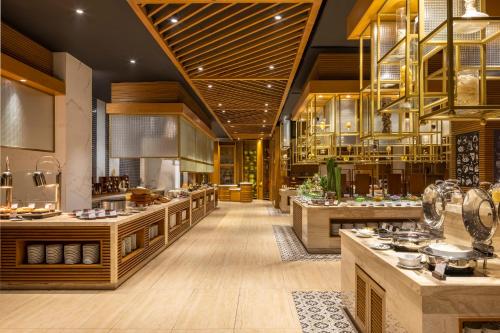 Una gran cocina con mostradores y mesas de madera en un restaurante. en Melia Vinpearl Thanh Hoa, en Thanh Hóa